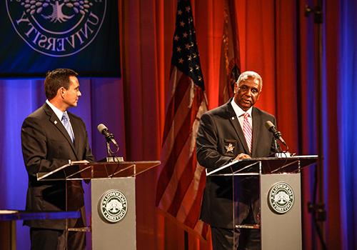 Two Jacksonville leaders speak to an audience from a stage